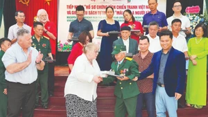 텍사스텍대학교 대표단이 참전 용사이자 부상 군인인 도쑤언투옌에게 서류를 전달하고 있다.