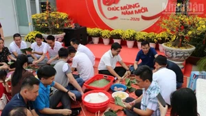 베텔 군사산업통신그룹(Viettel) 산하 메트폰(Metfone)의 베트남 및 캄보디아 직원들이 설(Tet) 명절을 맞아 함께 반쯩(Chung) 떡을 싸는 행사에 참여하고 있다. (사진: HUY VU)