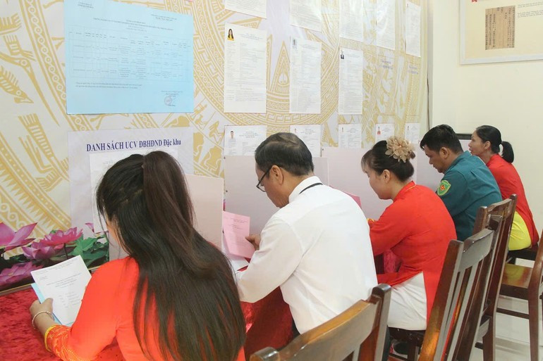 유권자들이 투표용지를 받아 선거에 참여하고 있다.