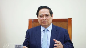 팜 민 찐 베트남 총리가 카타르 국무총리 겸 외교장관인 셰이크 모하메드 빈 압둘라흐만 빈 자심 알타니와 전화 회담을 하고 있다. (사진: VNA)