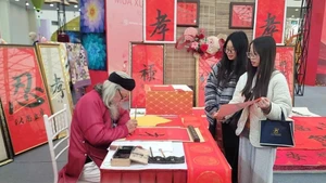 하노이에서 열린 박람회에서 젊은이들이 행운을 기원하며 서예를 찾고 있다. (사진: 베트남통신사)