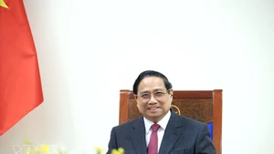 팜민찐 베트남 총리가 싱가포르의 로렌스 웡 총리와 전화 통화를 하고 있다. (사진: VNA)