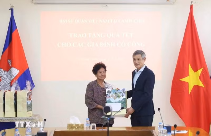 응우옌 민 부 캄보디아 주재 베트남 대사(오른쪽)가 2009년 베트남 총리로부터 공로 표창을 받은 대미 항전 유공자 하 티 에에게 설 선물을 전달하고 있다. (사진: VNA)