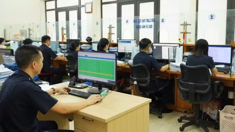 전자 시스템을 통해 수출입 화물의 통관 절차를 처리하고 있는 세관 직원들. (사진: NDO)