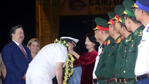 미국 장교와 수병들이 꽃다발로 환영받고 있다. (사진: VNA)