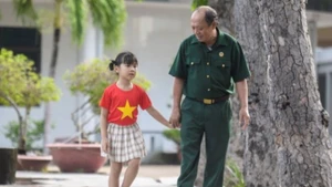 응우옌 찌 뜨엉 상사와 비나밀크 직원의 자녀가 롱닷 국가공헌자 및 상이군인 요양센터에서 함께하고 있다. (사진: 탄 빈)