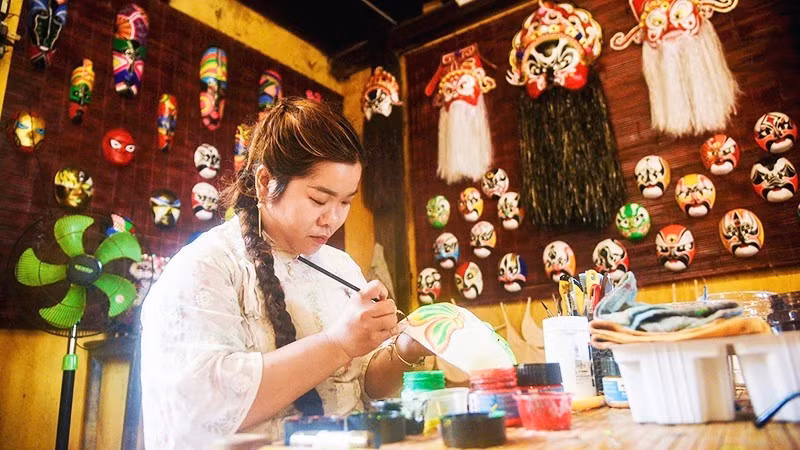  가족이 운영하는 전시 및 체험 공간에서 가면을 그리는 후옌 짱.