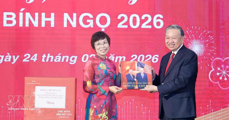 베트남통신사(VNA) 부 비엣 짱 사장(왼쪽)이 또 럼 당 서기장에게 사진집을 전달하고 있다. (사진: VNA)