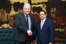 팜민찐 베트남 총리(오른쪽)와 에두아르트 스티파우트(Edouard Stiphout) ASML 수석 부사장이 15일 하노이에서 만나 악수를 나누고 있다. (사진: VNA)