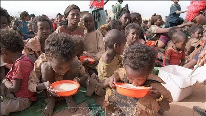 영양실조에 걸린 두 어린이가 에티오피아 동부 케브리베야 난민캠프에서 플라스틱 그릇에 담긴 우유를 마시고 있다. (사진: AFP/VNA)