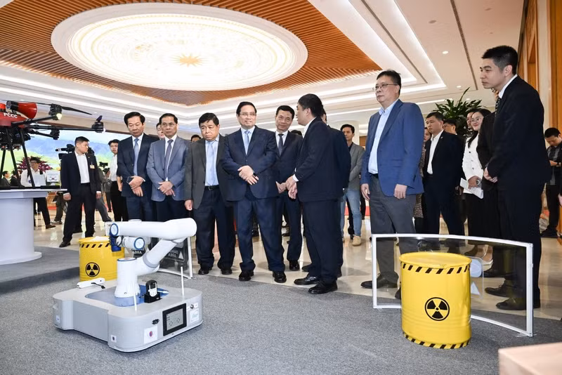 응오 만 띠엔 박사가 2025년 12월 하노이에서 열린 제3회 국가 디지털 경제 및 디지털 사회 포럼에서 팜 민 찐 총리와 기타 참석자들에게 로봇을 소개하고 있다. (사진: 베트남 과학기술원)