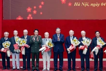 또럼 당 서기장(오른쪽 네 번째)과 르엉 땀 꽝 공안부 장관(왼쪽 네 번째)이 전직 공안 관계자들에게 꽃과 선물을 전달하고 있다. (사진: VNA)