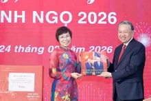 베트남통신사(VNA) 부 비엣 짱 사장(왼쪽)이 또 럼 당 서기장에게 사진집을 전달하고 있다. (사진: VNA)