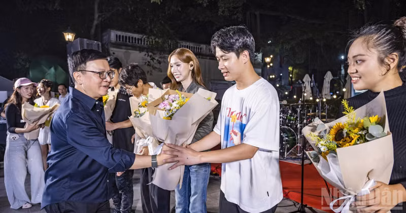 레 꾸옥 민 인민신문 편집장이 공연에 참여한 가수들에게 꽃다발을 전달하고 있다. (사진: THÀNH ĐẠT)