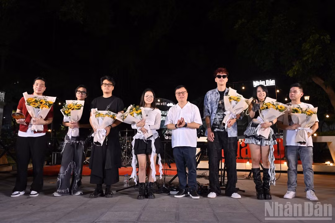 레 꾸옥 민 인민신문 편집장(사장)이 공연에 참여한 아티스트와 밴드에게 꽃다발을 전달하고 있다.