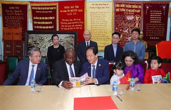 남아프리카공화국 마타멜라 시릴 라마포사 대통령(왼쪽에서 두 번째, 앉아 있음)이 보응우옌잡 장군의 가족을 방문하고 있다. (사진: VNA)