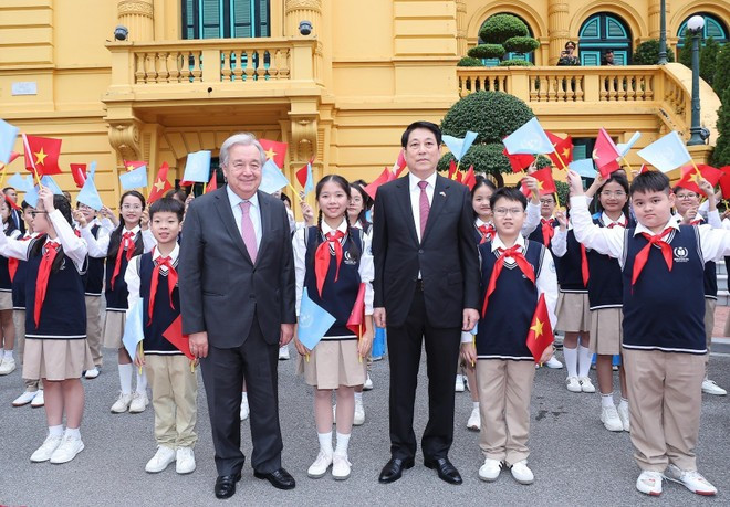 르엉 끄엉 국가주석과 안토니우 구테흐스 유엔 사무총장이 환영식에서 지역 어린이들과 함께 기념촬영을 하고 있다. (사진: VNA)