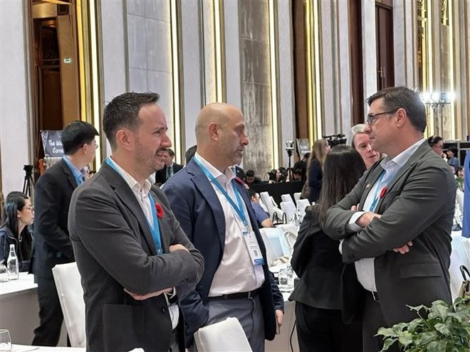 외국 대표단이 회의장 주변에서 대화를 나누고 있다. (사진: VNA)