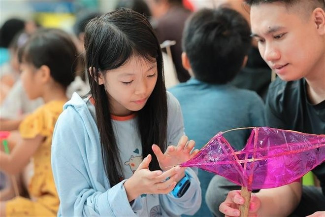 어린이들이 물고기 모양 등불 만들기를 체험하고 있다. (사진: VNA)