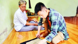 삼 꽁 단(오른쪽)이 지역사회 내에서 자료를 찾고 있다.