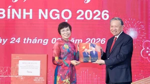 베트남통신사(VNA) 부 비엣 짱 사장(왼쪽)이 또 럼 당 서기장에게 사진집을 전달하고 있다. (사진: VNA)