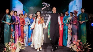 디자이너 도 찐 호아이 남과 그의 모델들이 관객들에게 인사를 하고 있다.