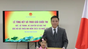 행사 참가 아동인 김짜미(왼쪽)가 주일 베트남 대사관으로부터 증명서를 받고 있다. (사진: VNA)