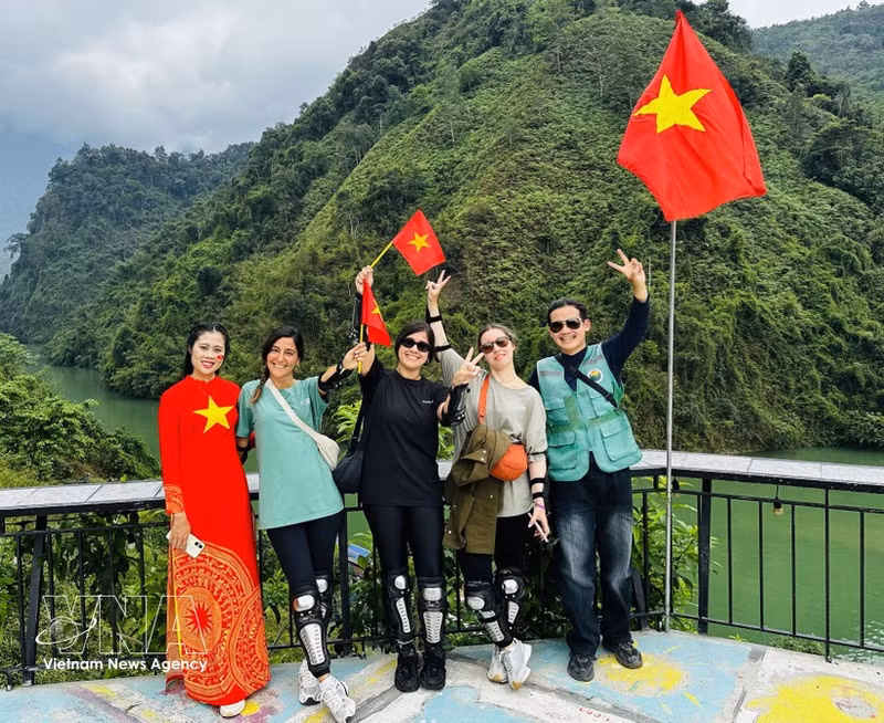  현지 주민들과 함께 기념사진을 찍는 외국인 관광객들. (사진: VNA)