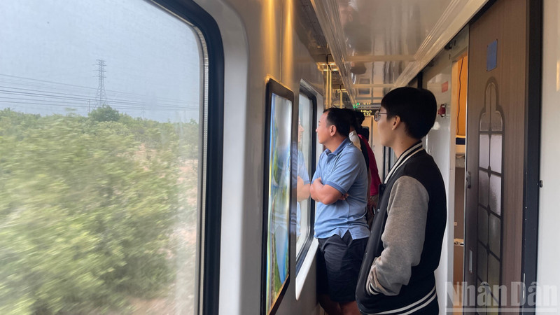 승객들이 객차 창문을 통해 펼쳐지는 풍경을 감상하고 있다.