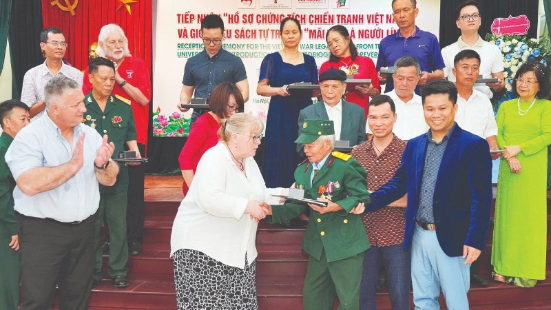 텍사스텍대학교 대표단이 참전 용사이자 부상 군인인 도쑤언투옌에게 서류를 전달하고 있다.