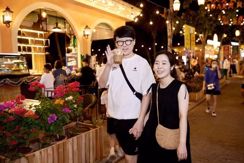 선셋타운의 Vui-Fest 바자에서 다양한 세계 요리를 즐기며 환한 미소를 짓는 한국인 관광객들. (사진: Sun Group)