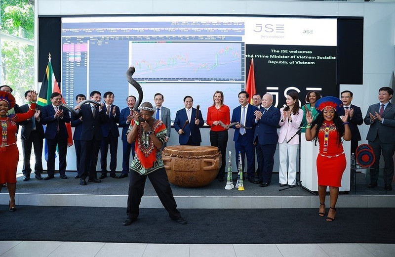 팜 민 찐 베트남 총리와 대표단이 요하네스버그 증권거래소에서 거래 개시를 알리는 타북을 하고 있다. (사진: VNA)