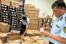 하노이시 시장관리 당국이 전자상거래 활동에서 위반 징후가 있는 상품을 점검하고 있다. (사진: 호앙 옌)