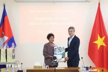 응우옌 민 부 캄보디아 주재 베트남 대사(오른쪽)가 2009년 베트남 총리로부터 공로 표창을 받은 대미 항전 유공자 하 티 에에게 설 선물을 전달하고 있다. (사진: VNA)