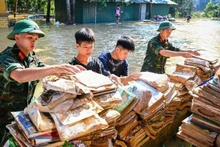 랑선성 후룽현 소수민족 기숙 중·고등학교에서 군인들과 학생들이 물에 젖은 책과 학용품을 말리고 있다. (사진: 탄닷)