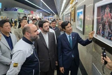 응우옌 르엉 응옥 대사가 개막식에 참석한 대표단에게 전시품을 소개하고 있다. (사진: 주이란 베트남 대사관)