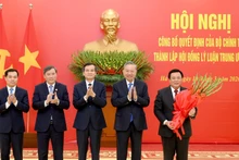 또 럼 당 서기장이 2026~2031년 임기 중앙이론위원회 설립 결정을 위원회 지도부에 전달하고 박수를 보내고 있다.