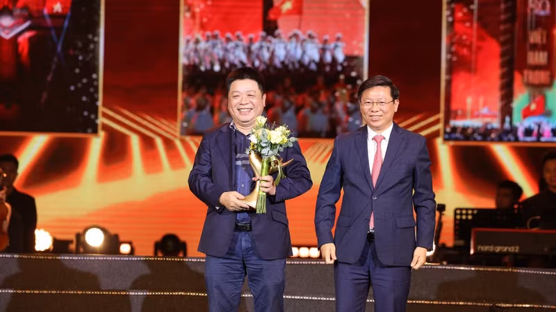 응우옌 꿰 딘 인민일보 부편집장이 ‘조국은 우리 마음 속에’ 콘서트 조직위원회를 대표해 쩐탄람 당 중앙위원 겸 당 중앙 선전교육대중동원위원회 부위원장으로부터 ‘공헌’ 훈장을 수여받고 있다.