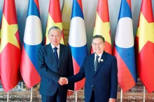 베트남 공산당 중앙위원회 또럼 서기장(왼쪽)과 라오스 국회 의장 사이솜폰 폼비한은 1일 비엔티안에서 만나 악수를 나누고 있다. (사진: VNA)