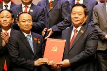 응우옌 쫑 응이아 당 중앙위원회 선전교육•대중동원위원회 위원장(오른쪽)이 타이 다이 응옥에게 정치국의 결정을 전달하고 있다. 타이 다이 응옥은 현재 자라이성 당위원회 서기로 임명됐다. (사진: VNA)