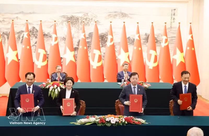 중국과 베트남 관계자들이 15일 베이징에서 또 럼 베트남 당 서기장 겸 국가주석과 시진핑 중국 당 총서기 겸 국가주석이 참석한 가운데 협력 문서에 서명하고 있다. (사진: VNA)